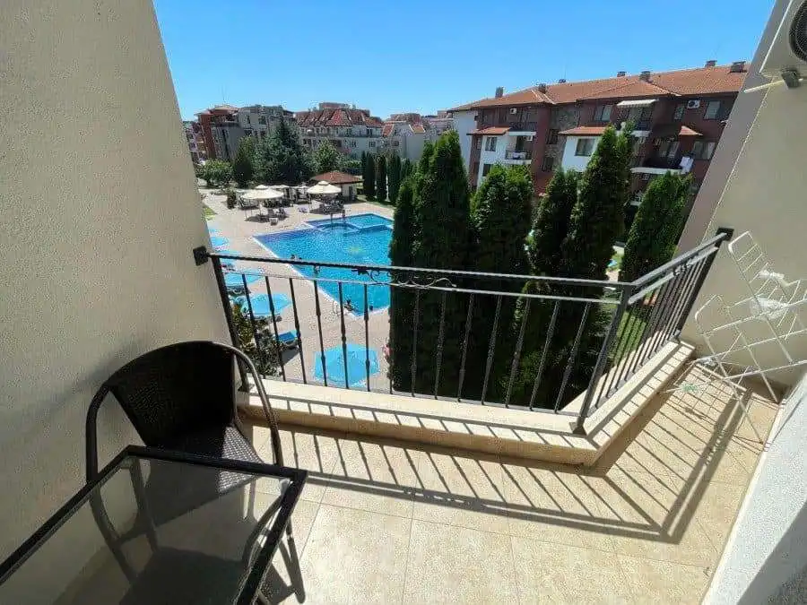 Balcony view of pool and garden from a 3-bedroom apartment in Apollon 5.