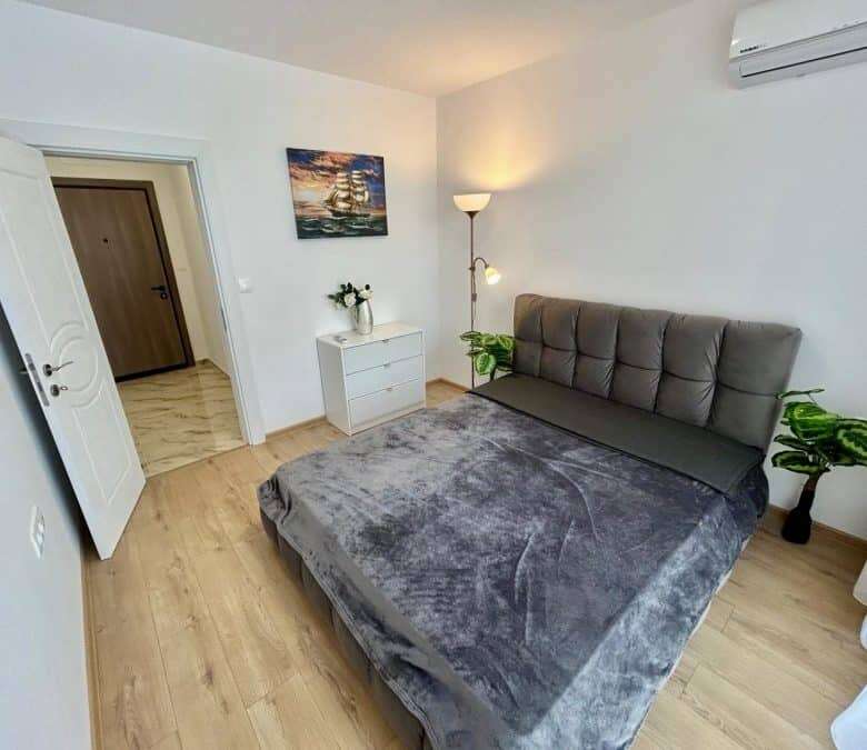 Apartment with pool views in Aphrodite Green, Sunny Beach, featuring modern decor and a spacious bed.