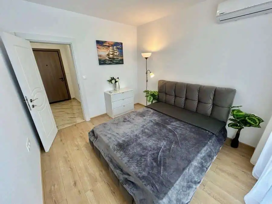 Apartment with pool views in Aphrodite Green, Sunny Beach, featuring modern decor and a spacious bed.