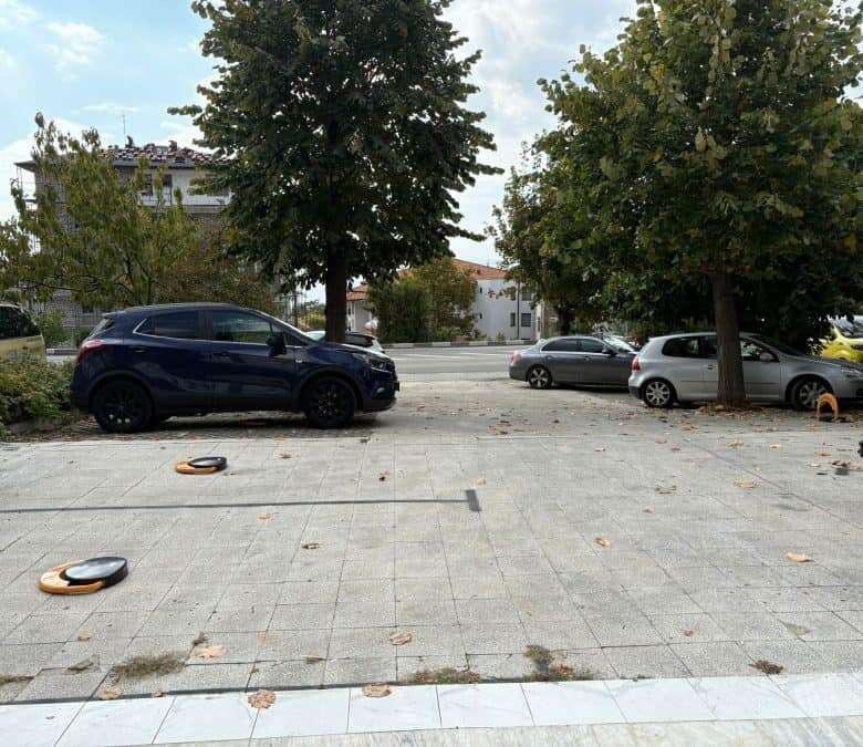 Spacious outdoor parking area with multiple vehicles and greenery, ideal for residents and visitors.