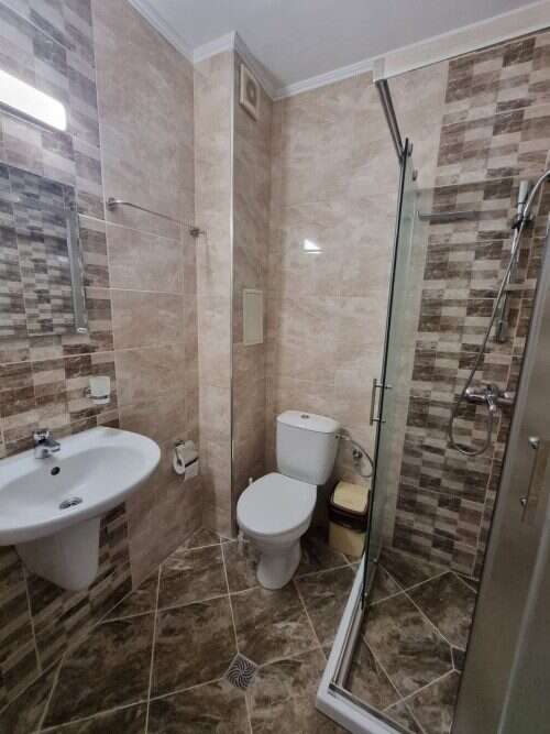 Modern bathroom featuring a shower, toilet, and sink in a stylish, compact space. Perfect for a comf.