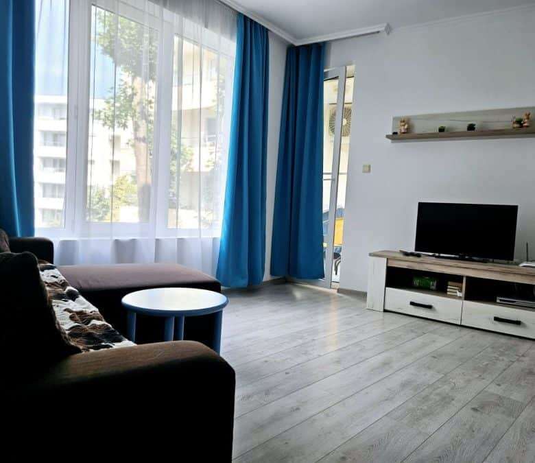 Bright living room with large windows, modern furniture, and pool views in Yassen, Sunny Beach.
