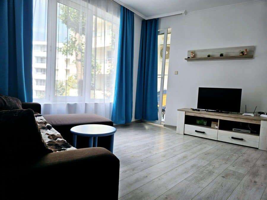 Bright living room with large windows, modern furniture, and pool views in Yassen, Sunny Beach.