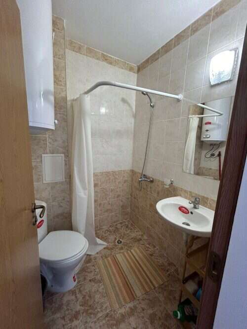 Small bathroom with shower, toilet, and sink in a top-floor apartment.
