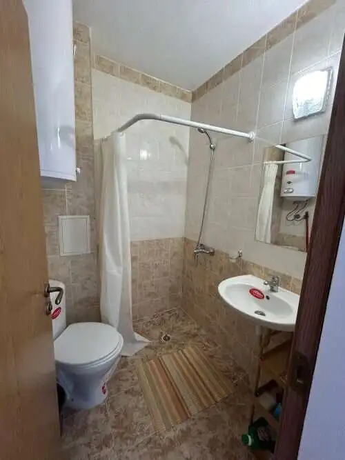 Small bathroom with shower, toilet, and sink in a top-floor apartment.