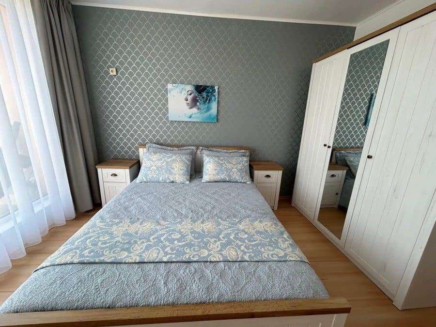 Bright bedroom with elegant furniture and large wardrobe.
