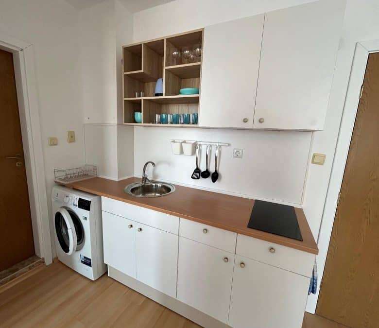 Cozy kitchen in a sunny 1-bedroom top floor apartment with modern decor and compact appliances.