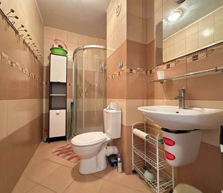 Small bathroom with shower, toilet, and sink in a furnished Sunny Beach apartment.