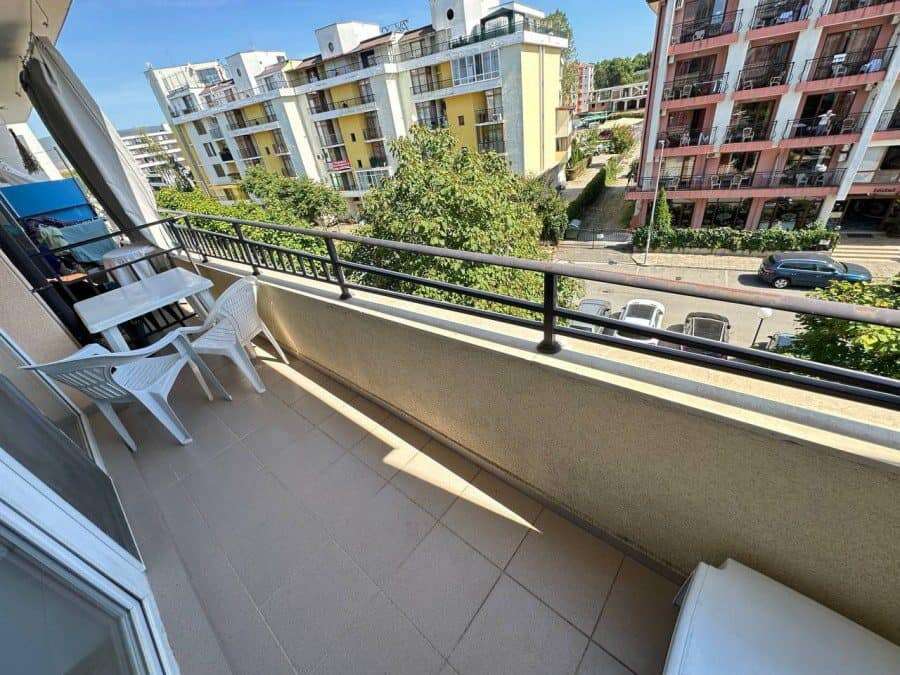 Balcony of a furnished 1-bedroom apartment in Sunny Beach with city views and outdoor seating.