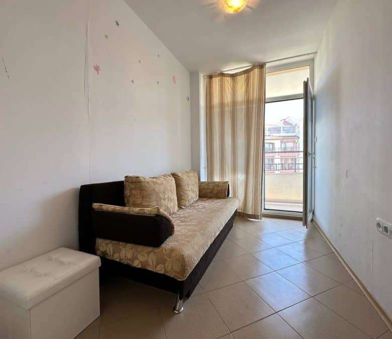 Interior of a furnished 1-bedroom apartment with a sofa and balcony in Sunny Beach center.
