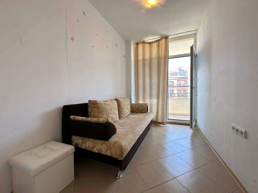 Interior of a furnished 1-bedroom apartment with a sofa and balcony in Sunny Beach center.