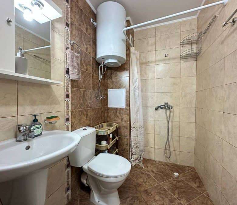Bathroom with shower, toilet, and sink in a top-floor apartment.