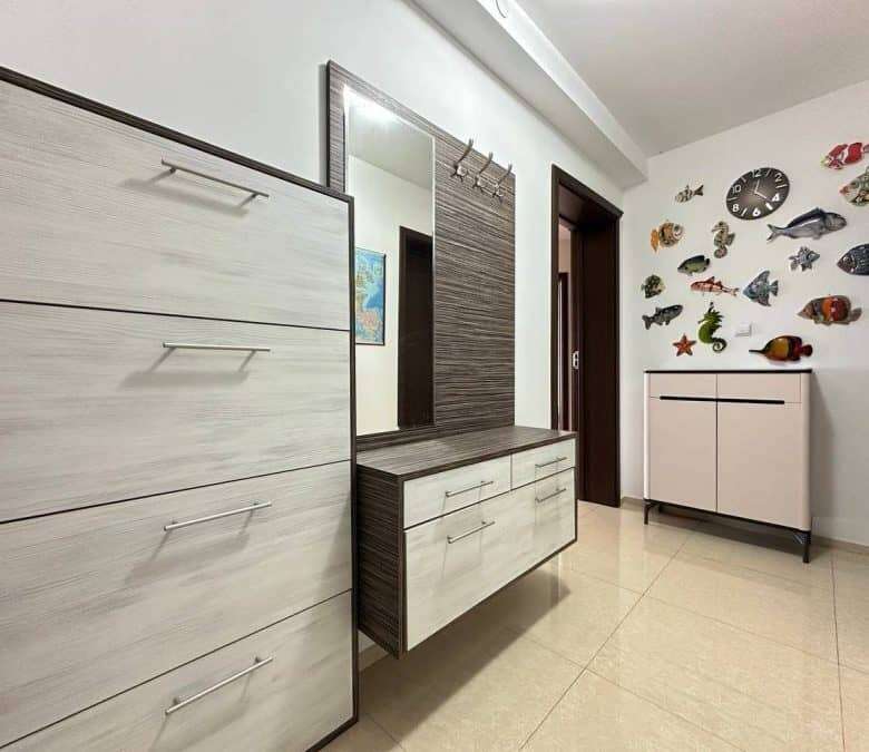 Stylish hallway interior featuring fish wall art, a mirror, and contemporary storage units.