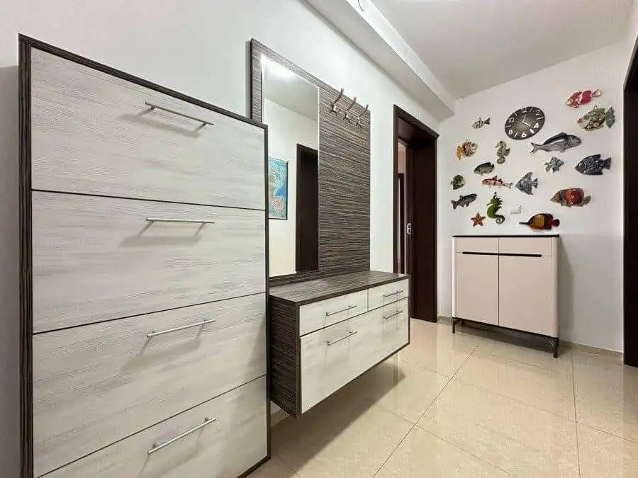 Stylish hallway interior featuring fish wall art, a mirror, and contemporary storage units.