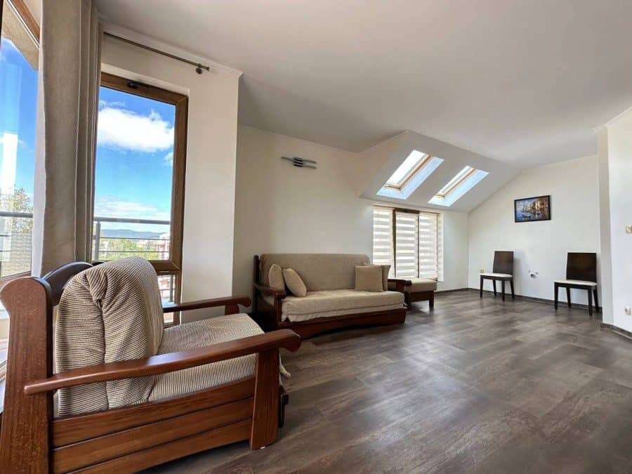 Modern top floor apartment living room with large windows and skylights in Sunny Beach. Spacious living area with comfortable seating, natural light, and scenic views.