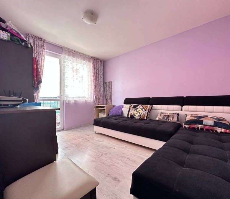 Bright living room with modern furniture, large window, and balcony view in Nessebar, Bulgaria.