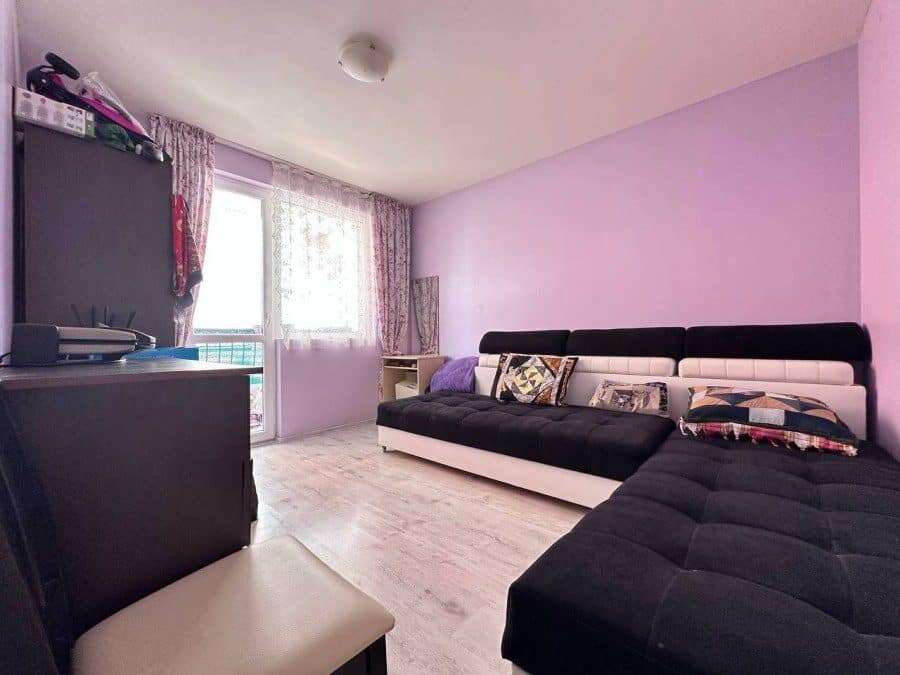 Bright living room with modern furniture, large window, and balcony view in Nessebar, Bulgaria.