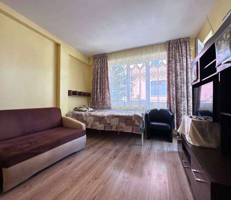 Bright 1-bedroom apartment just 300m from the sea in Nessebar, featuring a living area, bed, and mod.
