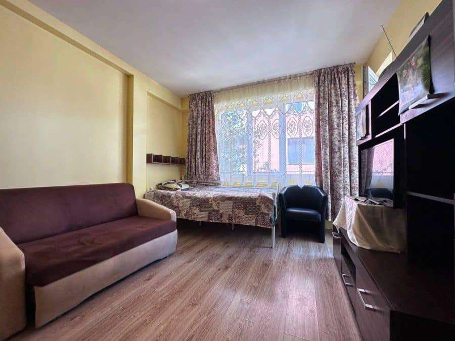 Bright 1-bedroom apartment just 300m from the sea in Nessebar, featuring a living area, bed, and mod.