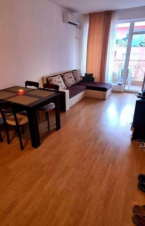 Bright living room with sofa and dining area near balcony.