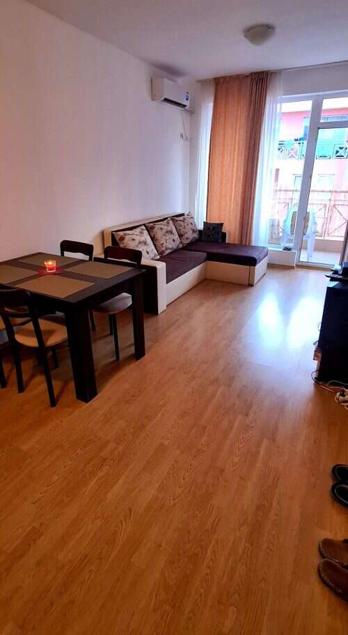 Bright living room with sofa and dining area near balcony.