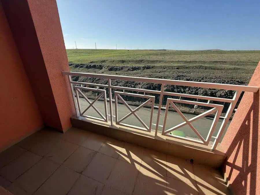 Balcony overlooking open fields and clear blue sky, perfect for relaxing outdoors.