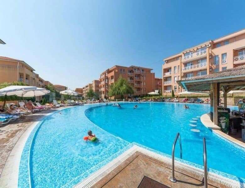 Pool area with clear water and sun loungers at Sunny Day 6 residential complex.
