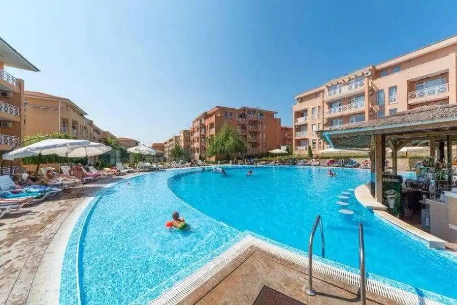 Pool area with clear water and sun loungers at Sunny Day 6 residential complex.