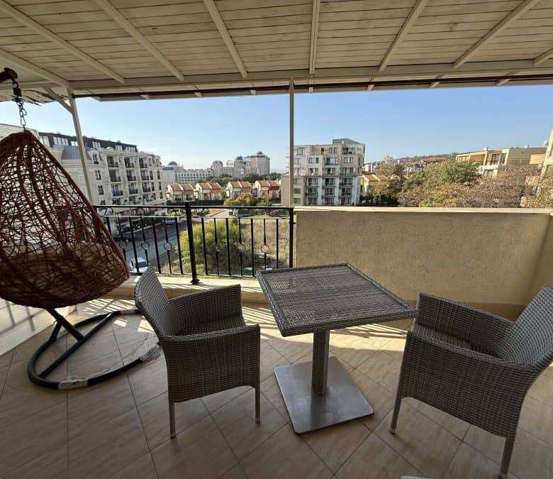 Spacious balcony with sea views, outdoor seating, and a hanging chair in Sveti Vlas.