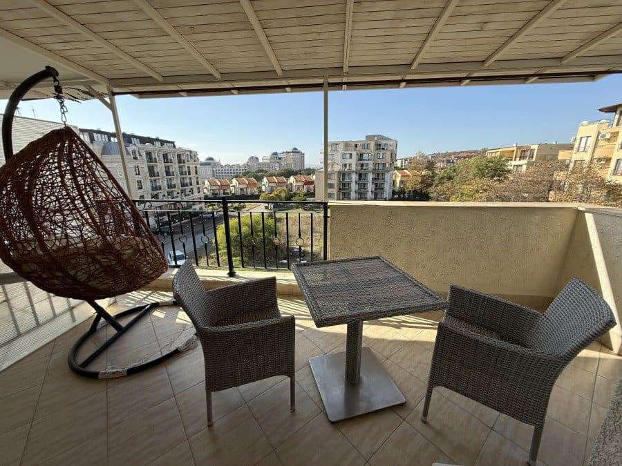 Spacious balcony with sea views, outdoor seating, and a hanging chair in Sveti Vlas.