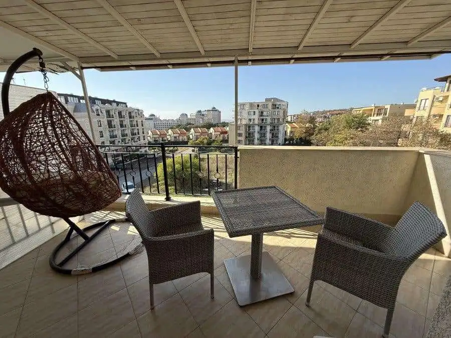 Spacious balcony with sea views, outdoor seating, and a hanging chair in Sveti Vlas.