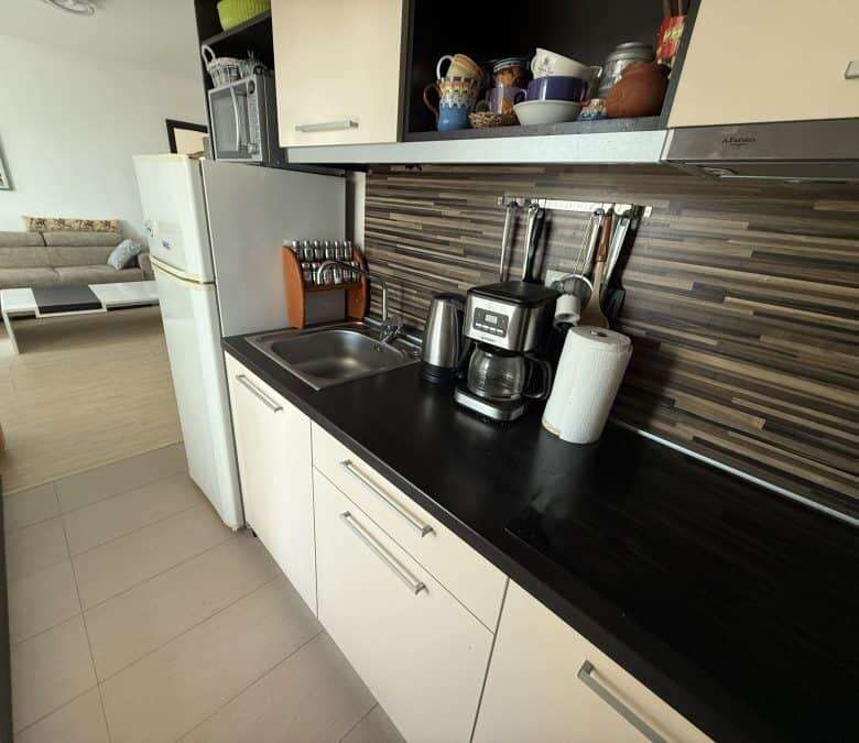 Bright, functional kitchen featuring a coffee maker, blender, and ample cabinet space.