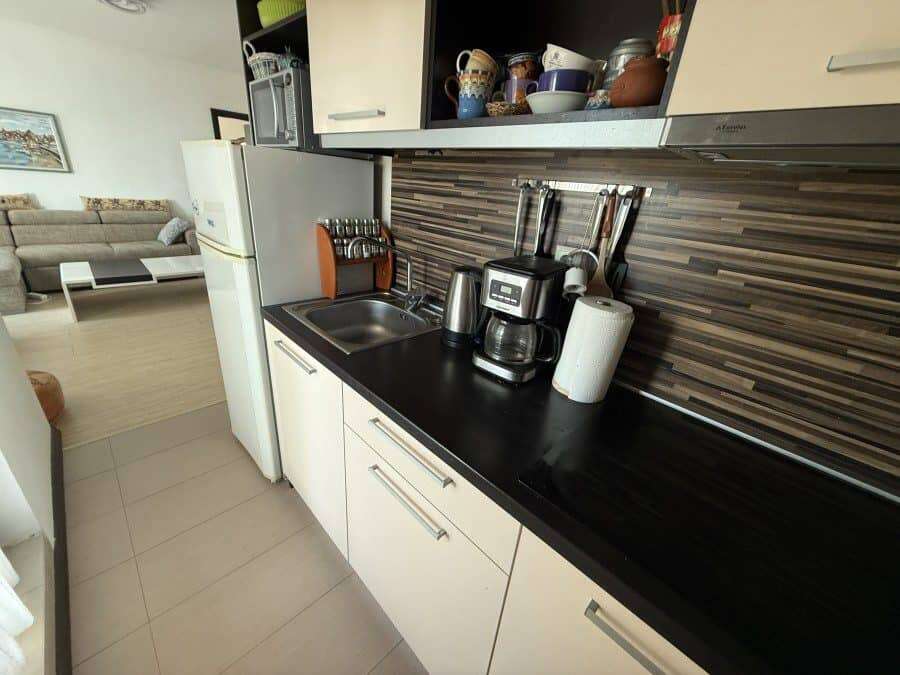Bright, functional kitchen featuring a coffee maker, blender, and ample cabinet space.