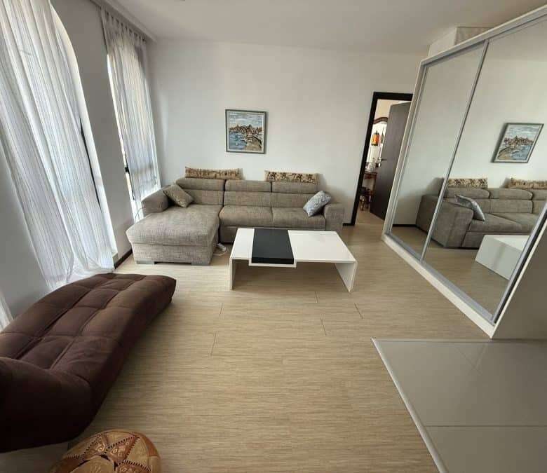 Bright living room with large windows and sea views in Sveti Vlas top floor apartment.
