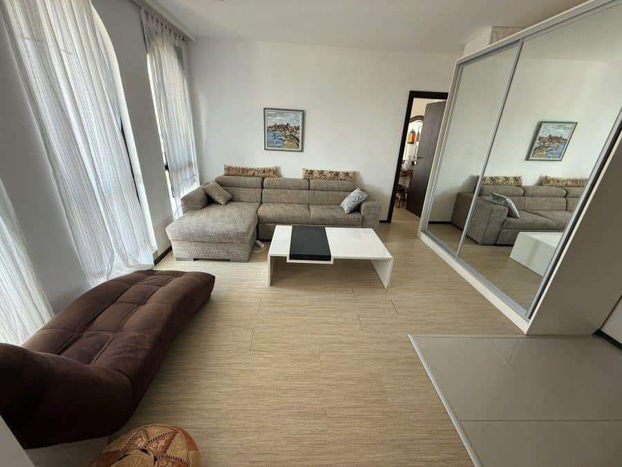 Bright living room with large windows and sea views in Sveti Vlas top floor apartment.
