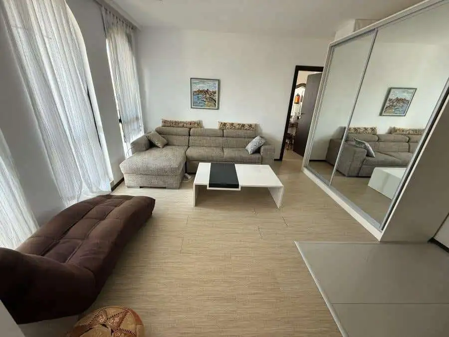Bright living room with large windows and sea views in Sveti Vlas top floor apartment.