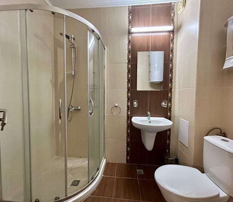 Bathroom with shower cabin, sink, and toilet in Apollon apartments, Ravda.