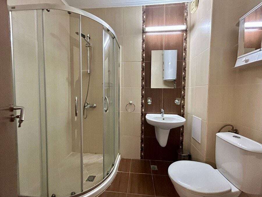 Bathroom with shower cabin, sink, and toilet in Apollon apartments, Ravda.