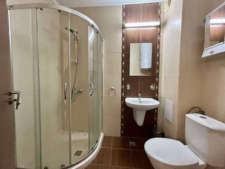 Bathroom with shower cabin, sink, and toilet in Apollon apartments, Ravda.