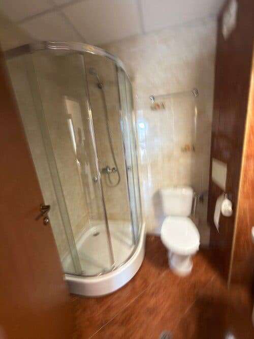 Bright bathroom featuring a glass shower enclosure and white fixtures.
