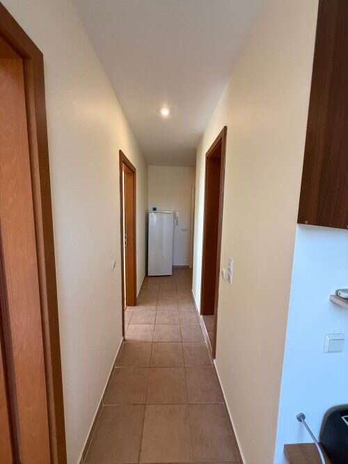 Bright hallway view of top-floor apartment near the sea.