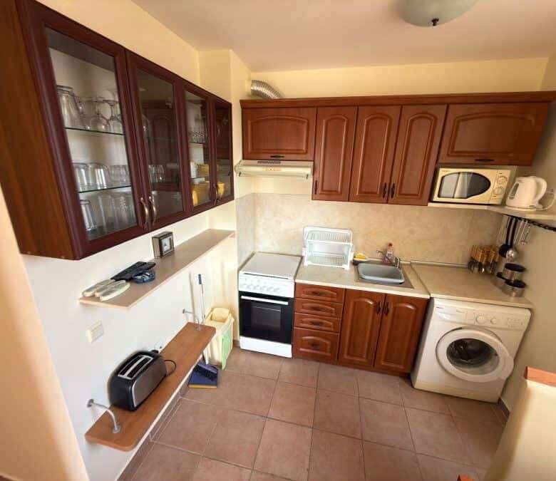 Bright kitchen with wooden cabinets and modern appliances in Sunny Beach.
