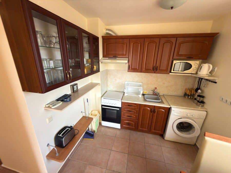 Bright kitchen with wooden cabinets and modern appliances in Sunny Beach.