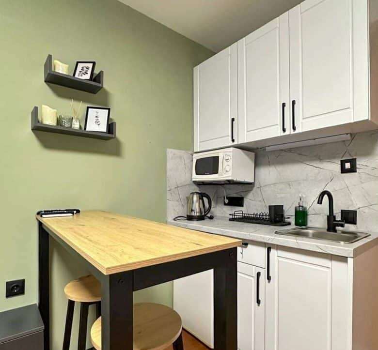 Compact kitchen with white cabinets and modern appliances.