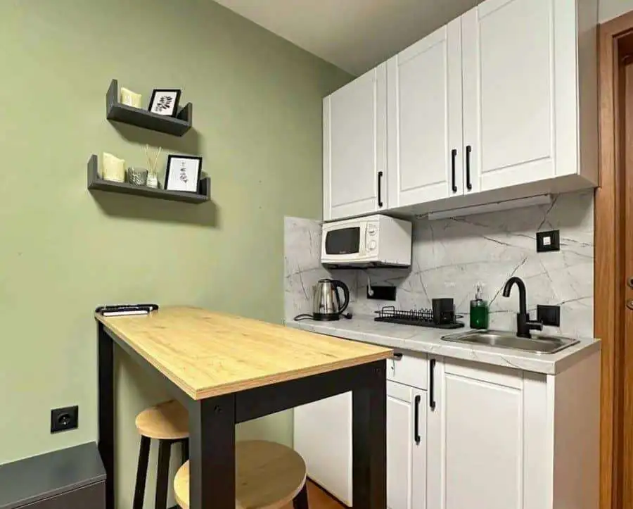Compact kitchen with white cabinets and modern appliances.