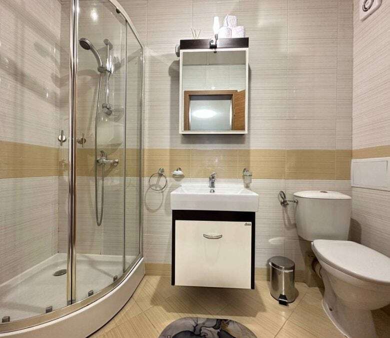 Modern bathroom with shower, sink, and toilet in a luxury seaside studio. Perfect for relaxing stays.