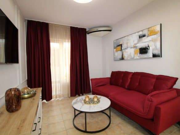 Bright living room with red sofa and modern decor in Sveti Vlas.
