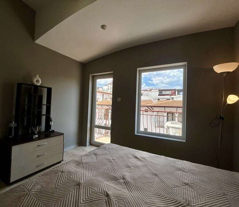 Bright bedroom with large windows overlooking the town and sea.