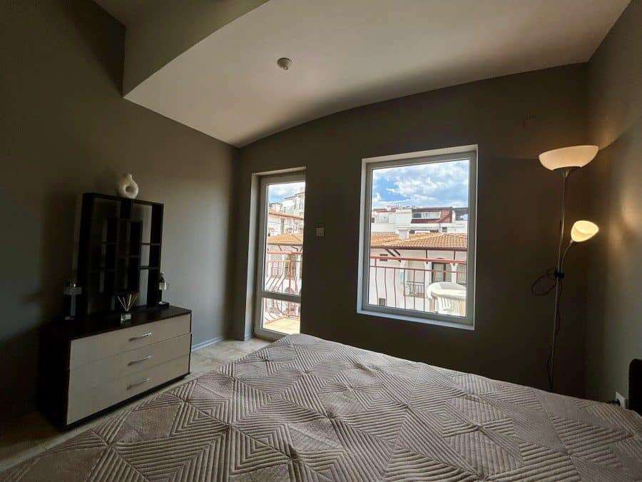 Bright bedroom with large windows overlooking the town and sea.