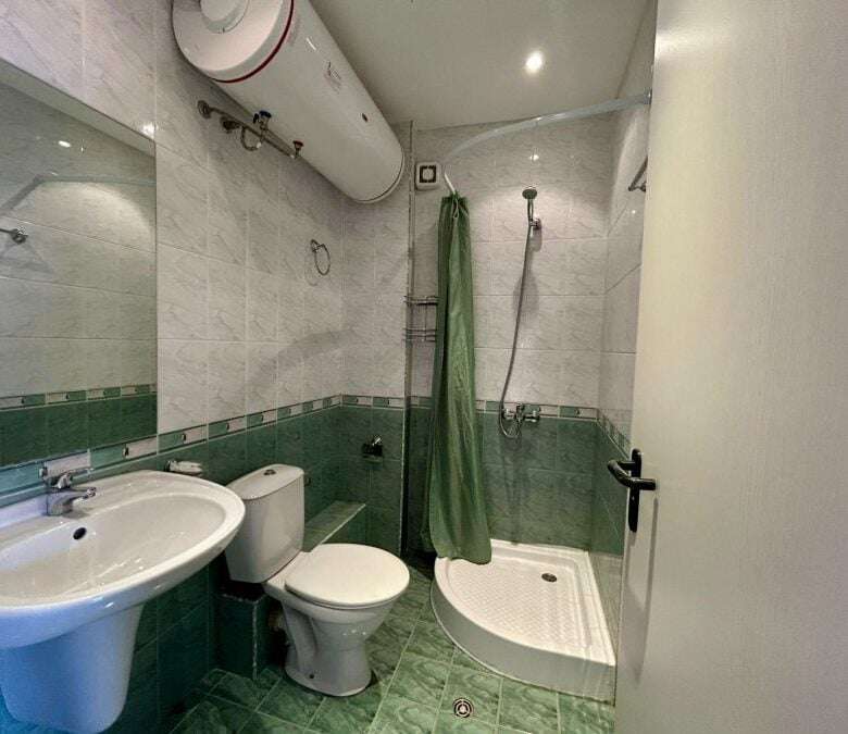 Bright, clean bathroom with shower, toilet, and sink in a seaside property.